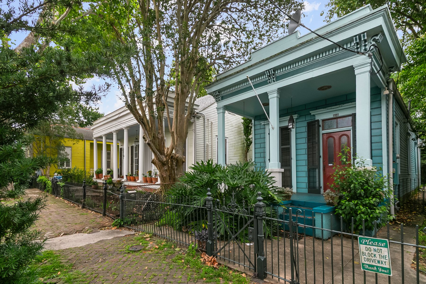 A row of restored historic New Orleans homes with columned porches in Algiers Point